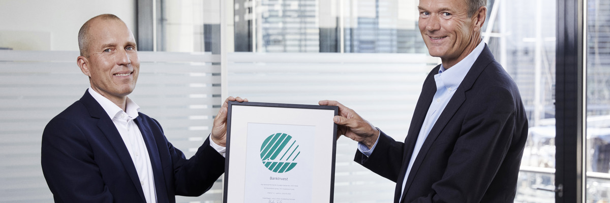 Martin Fabriansen, direktør i Miljømærkning Danmark, overrækker Svanemærke-certifikatet til BankInvests adm. direktør, Lars Bo Bertram.